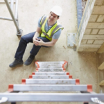 construction work at bottom of ladder holding knee | work accident lawyer