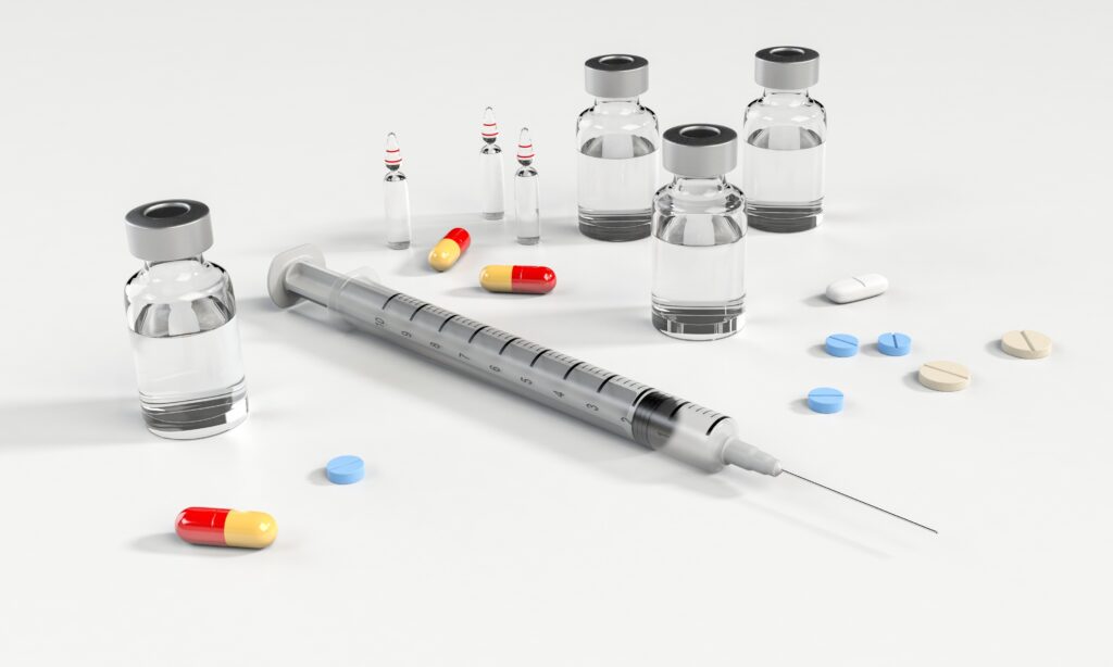 vials, syringe and pills on table | medical malpractice attorney